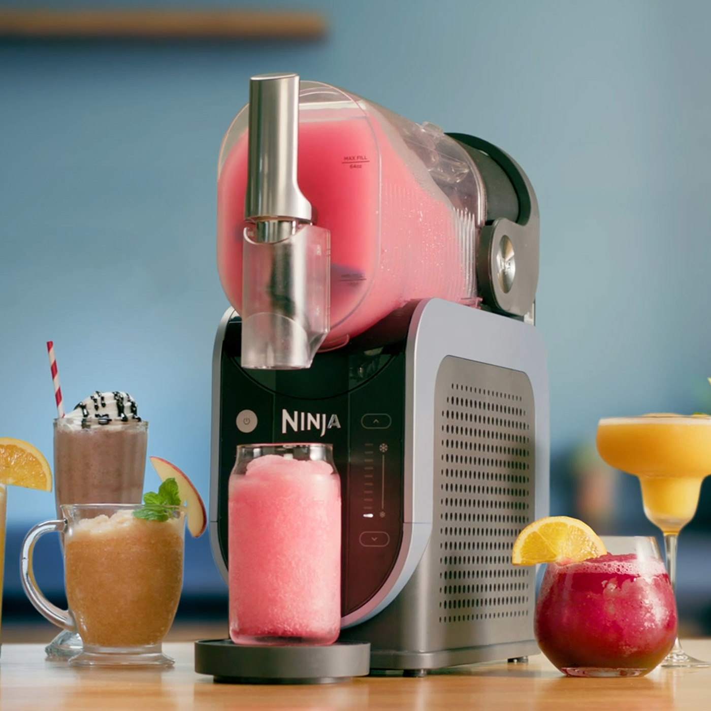 A Ninja Slush machine sat on a kitchen counter top with different slushi drinks
